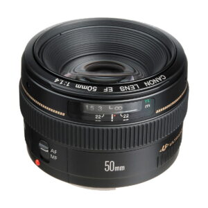 A Canon EF 50mm f/1.4 USM -objektiivi, musta runko ja etäisyysasteikkoikkuna, näkyy kulmasta korostaen lasia ja merkintöjä. Objektiivissa on automaatti- ja manuaalitarkennuksen kytkimet.