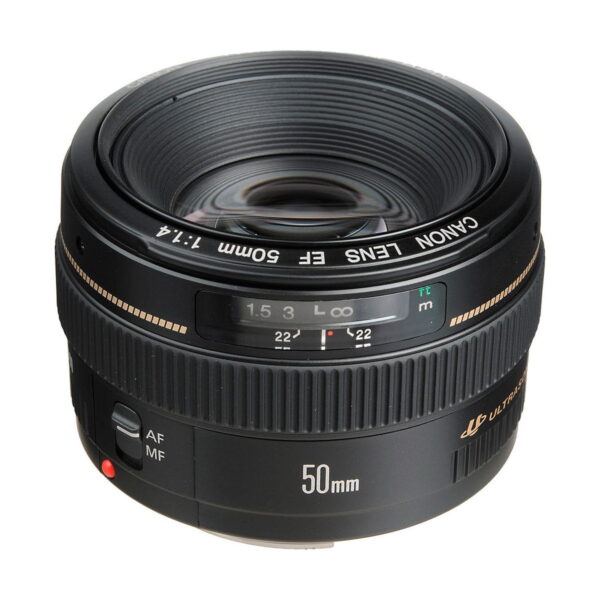A Canon EF 50mm f/1.4 USM -objektiivi, musta runko ja etäisyysasteikkoikkuna, näkyy kulmasta korostaen lasia ja merkintöjä. Objektiivissa on automaatti- ja manuaalitarkennuksen kytkimet.