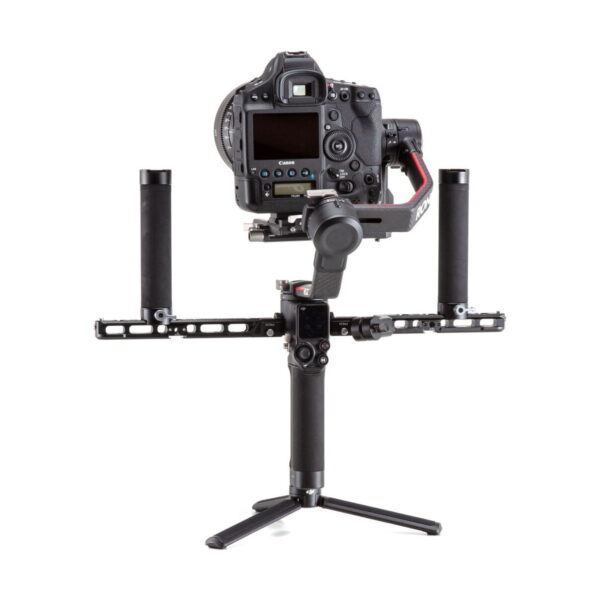 Ammattikäyttöön tarkoitettu DSLR-kamera on kiinnitetty DJI R Twist Grip Dual Handle for RS 2 & RSC 2 -laitteeseen, joka on kiinnitetty käsikäyttöiseen gimbaliin ja lepää pienellä jalustalla valkoista taustaa vasten.