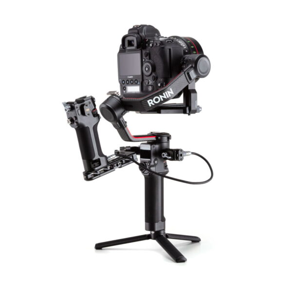 DJI-Tethered-Control-Handle-for-RS-2-04 Musta DSLR-kamera on kiinnitetty DJI Tethered Control Handle for RS 2 -ohjauskahvaan jalustan jalat ojennettuina, mikä mahdollistaa vakaan käsivaralta ohjaamisen sujuvia video- ja valokuvauskuvia varten.