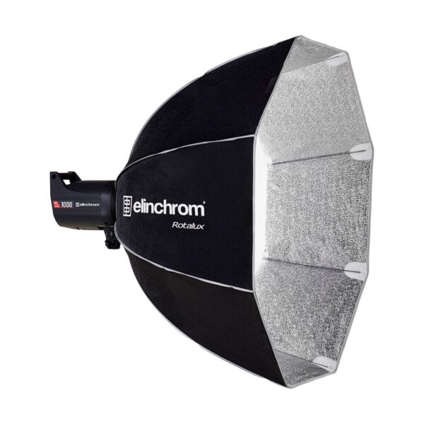 Elinchrom Rotalux Deep Octabox 100cm, musta softbox-valomodifiointilaite, jossa on hopeinen sisäpuoli, näkyy asennettuna studiostroboskooppivalaisimeen valkoista taustaa vasten.