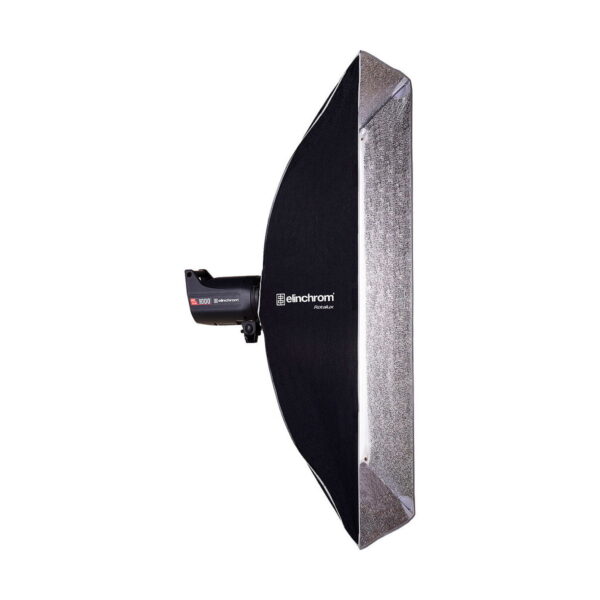 Elinchrom_Rotalux_Stripbox_50x130cm_003 Side view of the Elinchrom Rotalux Stripbox 50x130cm studio luminaire with black outer shell and silver reflective interior, mounted on a luminaire unit against a white background.