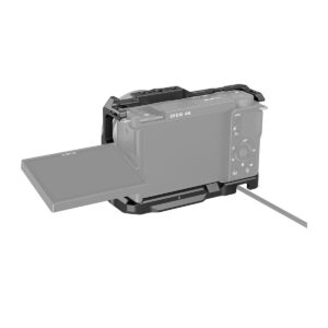 Sony ZV-E10 -digitaalikamera, jossa on ulos käännettävä LCD-näyttö, on osittain koteloitu SmallRig Cage for Sony ZV-E10 3531 -laitteeseen, kuvassa kaapeli kiinnitettynä valkoista taustaa vasten.