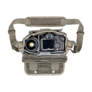 Think Tank Retrospective 5 V2.0 - Pinestone -laukussa, joka on kuvassa avattuna Canon DSLR -laitteen ja suuren objektiivin kanssa, on pehmustetut lokerot, olkahihna ja painikkeilla varustettu ulkoläppä.