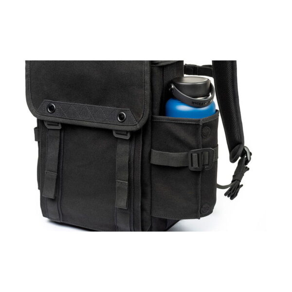 Lähikuva Think Tank Retrospective Backpack 15 -kamerareppu, musta, jossa on sininen vesipullo sivutaskussa, jota pitää säädettävä hihna. Mustassa repussa on napitetut läpät ja kestävä kangas.
