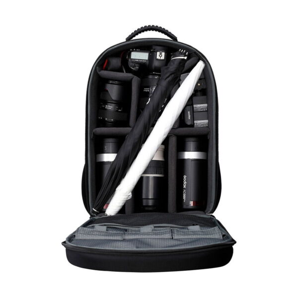 Avoin kamerareppu, jossa on järjestetyt lokerot, joihin mahtuu useita kameran objektiiveja, kameran runko, akut, taitettu valokuvaussateenvarjo ja Godox AD300 Pro Outdoor 2-Flash Kit.