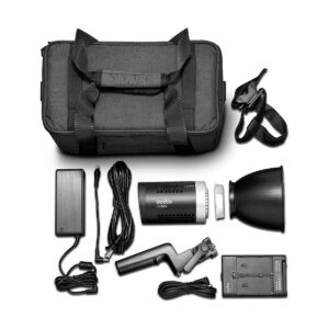 Godox ML60Bi Led videovalo -LED-valo näkyy valkoisella pohjalla mustan kantolaukun, salamalaitteen, heijastimen, virtajohtojen, akkulaturin, kädensijan ja olkahihnan kanssa.