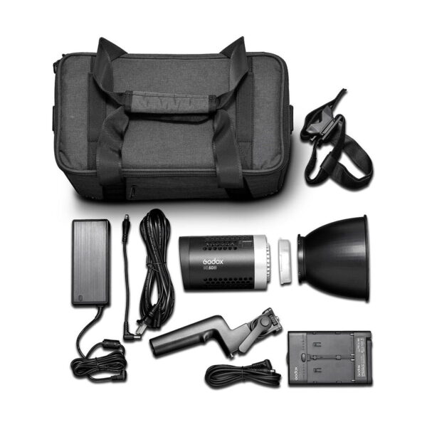 Godox ML60Bi Led videovalo -LED-valo näkyy valkoisella pohjalla mustan kantolaukun, salamalaitteen, heijastimen, virtajohtojen, akkulaturin, kädensijan ja olkahihnan kanssa.
