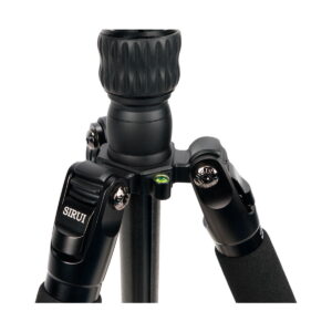 Close-up of the top of the black Sirui Traveler 7VA tripod, highlighting the footrests, tension knobs, built-in bubble level and foam padding on the upper legs.