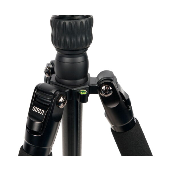 Close-up of the top of the black Sirui Traveler 7VA tripod, highlighting the footrests, tension knobs, built-in bubble level and foam padding on the upper legs.