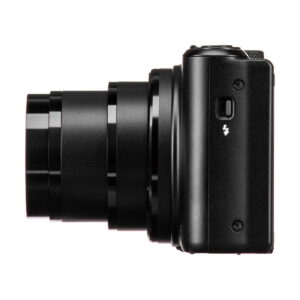 The black Canon PowerShot SX740 HS compact camera, with the lens extended, is shown sideways against a white background. A flash symbol appears on the body above a small button.