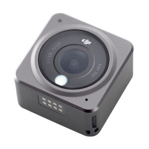 The DJI Action 2 Dual-Screen Combo is a compact, square-shaped action camera with a large lens, visible aperture markings, metallic finish and small indicator lights on the side.