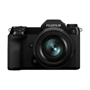 Fujifilm GFX 100S -järjestelmäkameran etukuva mustana, jossa on suuri objektiivi, useita valintakiekkoja ja etsin, valkoista taustaa vasten.