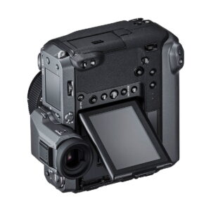 Fujifilm GFX 100, musta digitaalikamera, jossa on suuri elektroninen etsin, kallistettu LCD-näyttö ja useita ohjauspainikkeita, on kuvattu takaa hieman vasemmalta valkoista taustaa vasten.