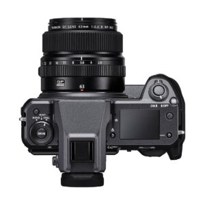 Fujifilm GFX 100 -digitaalikameran yläkuva, johon on kiinnitetty FUJINON GF 63mm -objektiivi, jossa näkyy valintakiekot, painikkeet, pieni näyttö ja päälle/pois-kytkin.