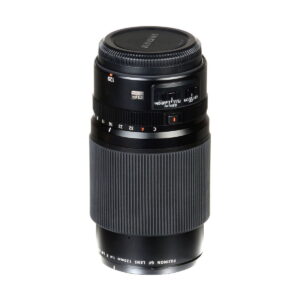 Fujinon_120mm_f_4_Macro_R_LM_OIS_WR_003 Fujifilm Fujinon GF 120mm f/4 Macro R LM OIS WR -objektiivi mustana, jossa on kuvioitu tarkennusrengas, aukon merkinnät ja objektiivin suojus, seisoo pystyssä valkoisella taustalla.