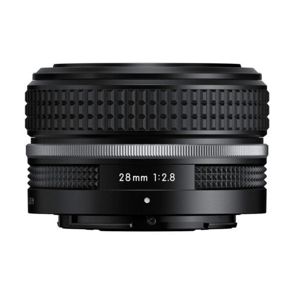 Nikon_Nikkor_Z_28mm_f_2_8_002 A Nikon Nikkor Z 28mm f/2.8 SE -objektiivi musta kameran objektiivi, jossa on kuvioitu otepinta ja toivottu rengas, jossa lukee 28mm 1:2.8. Objektiivia katsellaan sivulta valkoista taustaa vasten.