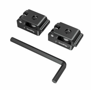 Kaksi mustaa SmallRig 2418 Universal Spring -jousikaapelikiinnikettä (2 kpl) näkyy mustan L-muotoisen kuusiokoloavaimen yläpuolella valkoisella pohjalla. Kummassakin puristimessa on keskireikä, urat ja siinä näkyy tuotemerkki.