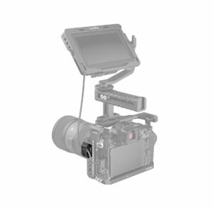 Suurella objektiivilla varustettu digitaalikamera on metallihäkissä, jonka päällä on kenttämonitori käsivarressa ja kahvassa. Kamera ja monitori on liitetty toisiinsa SmallRig 2418 Universal Spring Cable Clamp -jousipidikkeellä (2 kpl). Kuvassa on valkoinen tausta.
