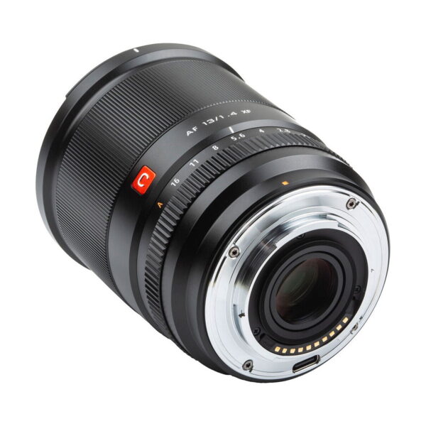 Lähikuva Viltrox AF 13mm f/1.4 -objektiivi, Fuji X näyttää sen mustan linssin, metallisen kiinnikkeen, elektroniset koskettimet ja merkityt aukko- ja tarkennusrenkaat valkoista taustaa vasten.