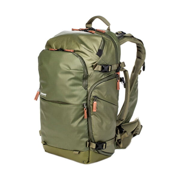 The Shimoda Designs Explore v2 25 Starter Kit Camera Backpack in green features multiple zippered compartments, adjustable padded straps, side compression straps, tan zipper pulls, a sturdy rectangular shape and a waist belt for extra support.