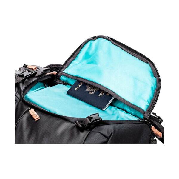 The green Shimoda Designs Explore v2 25 Starter Kit camera backpack is opened to reveal a US passport, partially hidden in the inside pocket.