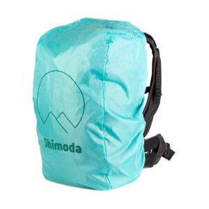 Green Shimoda Designs Explore v2 25 Starter Kit camera backpack with black straps, padded hipbelt and matching rain cover with minimalist mountain logo and the word "Shimoda".