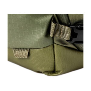 Close up of the Shimoda Designs Explore v2 25 Starter Kit camera backpack, green with visible green and olive green fabric, visible stitching, strap ties, plastic buckle and detailed material construction.