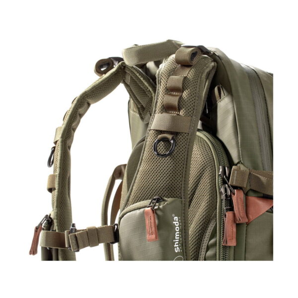 Close-up Shimoda Designs Explore v2 25 Starter Kit camera backpack, green with accent padded shoulder straps, mesh back, multiple adjustable straps and brown zipper pulls. Durable material for comfort and support.