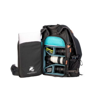 Shimoda Designs Explore v2 30 camera backpack, black includes several padded compartments for camera bodies, lenses and accessories. Its front flap opens to reveal organized gear and a laptop that partially slides out of the side pocket.