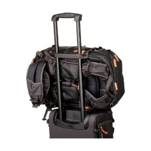 The Shimoda Designs Explore v2 30 camera backpack, black, is attached to a rolling suitcase with extended handles and organized storage pockets.