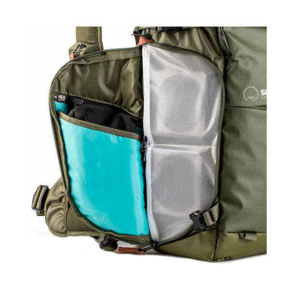 Shimoda Designs Explore v2 30 -kamerareppu, vihreä, on avoin oliivinvihreä muotoilu, jossa on sisätiloja, kuten turkoosi hiha ja kaksi verkkovetoketjullista taskua organisoitua säilytystä varten.