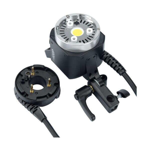 Close-up of the Godox AD-H400P Flashhead Jatke, a black electronic device with a clamp clip and a removable circular component connected by cable with several gold pins and a light or sensor element in the middle.