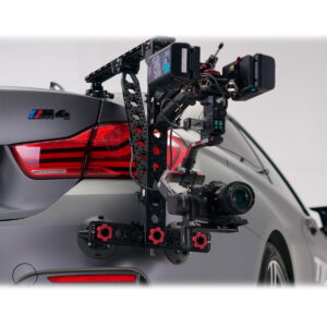 Tilta Hydra Alien Car Mounting System (V-Mount) on asennettu useilla kameroilla ja laitteilla harmaan BMW M4:n takaosaan, ja se on kiinnitetty imukupeilla takapyörän yläpuolelle ja lähelle takavaloa.