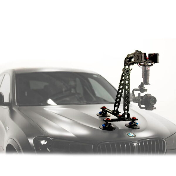 Tilta Hydra Alien Car Mounting System (V-Mount) on kiinnitetty harmaan BMW:n konepeltiin, mikä mahdollistaa vakaan kuvaamisen ajoneuvosta käsin. Tausta näyttää enimmäkseen valkoiselta ja epäselvältä.