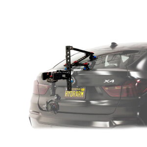 Tilta Hydra Alien Car Mounting System (V-Mount), jossa on vakauttamisvarsi, on asennettu mustan BMW X4:n takaosaan, ja se pitää ammattikäyttöön tarkoitettua kameraa, joka on suunnattu auton taakse. Rekisterikilvessä lukee HYDRAARM.