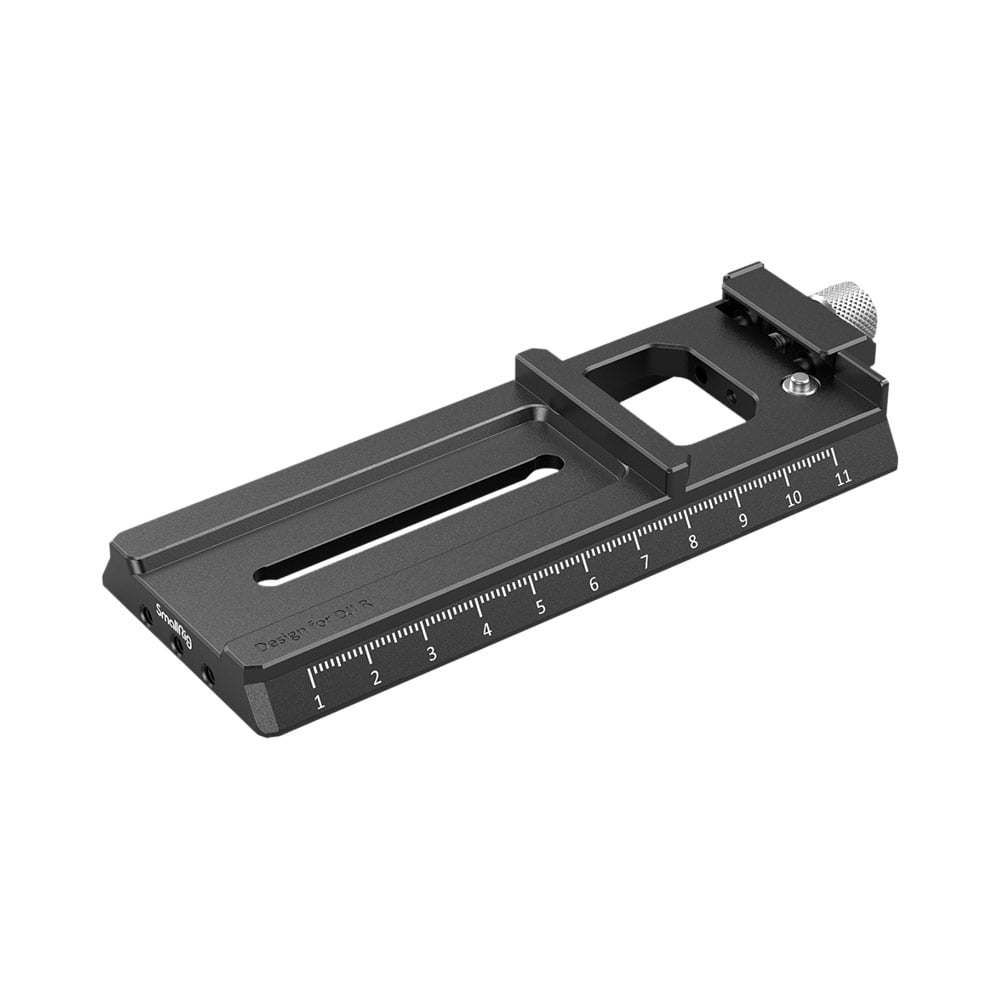 The SmallRig 3061 QR plate for the Ronin RS2/RSC2 is a black metal mounting plate with a grooved centre, a numbered scale and a silver knob at one end.