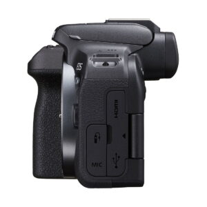 Sivunäkymä Canon EOS R10 -järjestelmäkameran musta, osoittaa kahva rakenne ja peitetty HDMI, MIC, ja USB-portit, etsimen ja tilan valitsin osittain näkyvissä päälle.