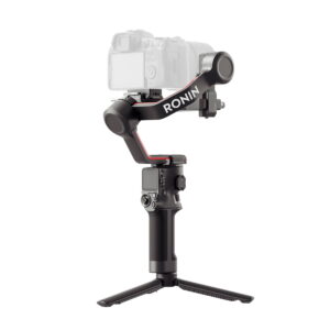 Musta DJI RS 3 -gimbaali kameranvakain, jossa on pieni jalusta ja sen päälle asennettu digitaalikamera, valkoista taustaa vasten.