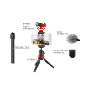 Boya BY-VG330 Video-Kit sisältää minijalustan, jatkoputken, videomikrofonin, jossa on karvainen tuulisuoja, ja kiinnittimen, jossa on kylmäkenkäkiinnitys, kaikki merkitty. Asetelmassa on kiinnitetty puhelin, jossa näkyy kaksi ihmistä.