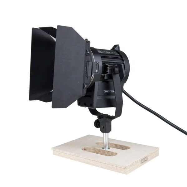 Musta studiospotkulamppu, jossa on lato-ovet, on asennettu Kupo KAB-015 Apple Box Set -laitteeseen sijoitettuun metallijalustaan. Valon takaosasta lähtee sähköjohto.