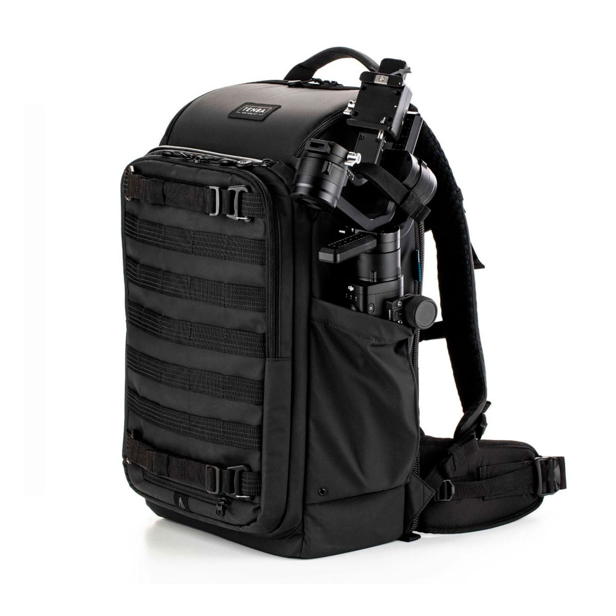 Tenba Axis V2 24L Backpack -kamerareppu on musta kameravarusteiden reppu, jossa on pehmustetut olkahihnat, sivu- ja etutaskut sekä ulkoiset hihnat. Kuvassa on kameran vakaaja yhdessä sivutaskussa valkoista taustaa vasten.