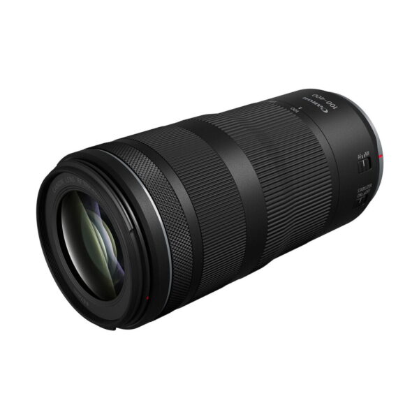 A Canon RF 100-400mm f/5.6-8 IS USM -objektiivi, musta telezoom-objektiivi, jossa on kohokuvioidut tarkennus- ja zoom-renkaat sekä näkyvä linssilasi, esillä valkoisella taustalla.