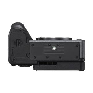 sony_fx30_kahvalla_02 Sony FX30 -videokameran mustan rungon alareunan näkymä, jossa näkyy akkulokeron kansi, jalustakiinnike, kuvioidut pinnat ja useita portteja.