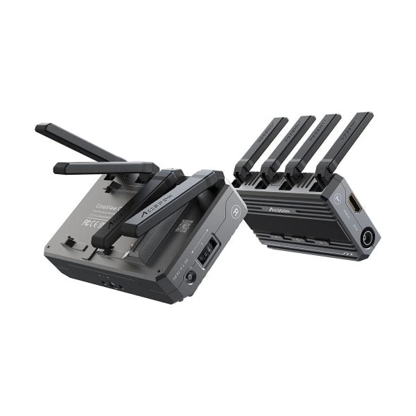 Kaksi Accsoon CineView Quad Transmission HDMI/SDI musta langatonta videolähetintä, joissa on useita antenneja, on asetettu eri kulmiin valkoiselle taustalle - yksi makaa tasaisesti, toinen pystyssä, ja niiden portit ja tuuletusaukot näkyvät.