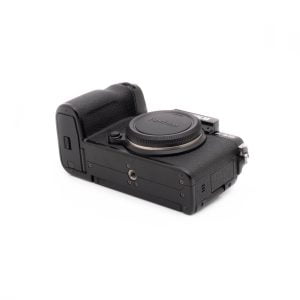 Musta Fujifilm X-S10 (SC 1189) - Käytetty kamerarunko, joka on kuvattu ilman objektiivia, on käännetty niin, että sen kuvioitu kahva ja portit näkyvät valkoista taustaa vasten.