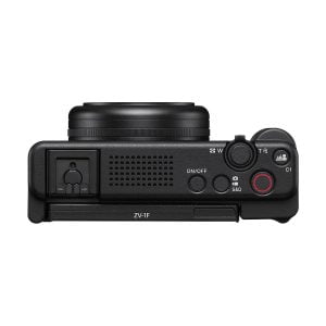 Sony ZV-1F -kompaktikamera ylhäältä katsottuna: musta runko, pyöreä objektiivi, ohjauspainikkeet, on/off-kytkin, zoomausvipu, sisäänrakennettu mikrofoni ja vasemmanpuoleinen katettu portti. Etupuolella on merkintä "ZV-1F".