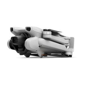The compact grey DJI Mini 3 + Smart Controller is pictured folded for storage, with the camera and propeller arms neatly against the body on a white background.