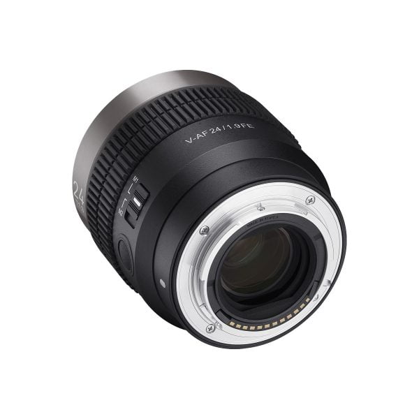 Mustaa Samyang V-AF 24mm T1.9 - Sony FE -objektiivia käännetään niin, että sen elektroniset koskettimet, metallinen kiinnitys, sivukytkimet ja tynnyrissä olevat merkinnät "V-AF 24/1.8 FE" ja "24" näkyvät.