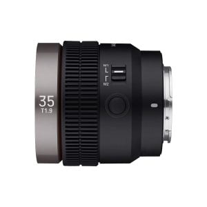 Samyang V-AF 35mm T1.9 for Sony FE on musta kameraobjektiivi, jossa on mattahopea rengas, jossa lukee "35 T1.9". Siinä on manuaali- ja lukituskytkimet, kuvioitu tarkennusrengas ja metallinen kiinnitysjalusta, jotka näkyvät valkoisella pohjalla.